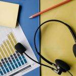 Call Center Headset auf Papierunterlage mit Stift und Tabelle