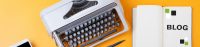 Schreibmaschine und Buch auf orangefarbenem Hintergrund. BLOG in Großbuchstaben zu lesen.