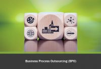 Business Process Outsourcing (BPO. Holzwürfel auf grünem Hintergrund, mit verschiedenen Symbolen.